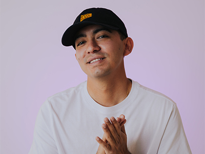 DJ Crave headshot in black hat and white shirt